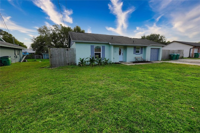 1491 Lavender St, Deltona, FL 32725 - view of front of property with a front lawn, fence, driveway, and a garage