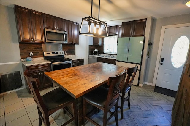 1491 Lavender St, Deltona, FL 32725 - kitchen with backsplash, light countertops, a sink, and stainless steel appliances