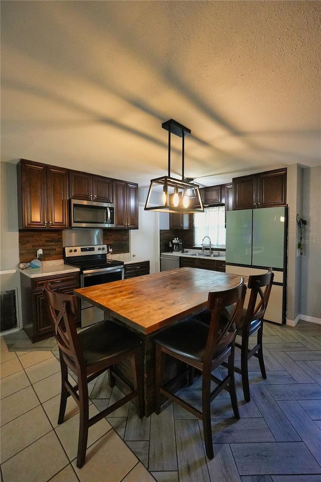 1491 Lavender St, Deltona, FL 32725 - dining area featuring a textured ceiling, baseboards, and visible vents