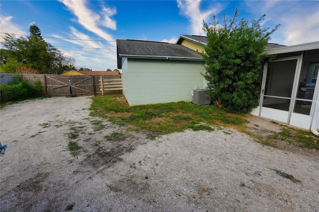 1491 Lavender St, Deltona, FL 32725 - view of property exterior with a gate, fence, concrete block siding, a sunroom, and central AC