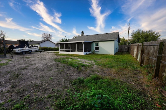 1491 Lavender St, Deltona, FL 32725 - rear view of house with a sunroom, a fenced backyard, a yard, and concrete block siding
