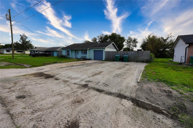 1491 Lavender St, Deltona, FL 32725 - single story home with dirt driveway, an attached garage, fence, and a front lawn