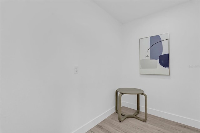 spare room with baseboards and light wood finished floors