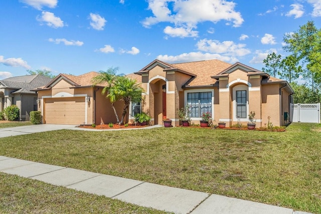 view of front of house with an attached garage, fence, concrete driveway, and a front yard