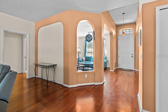 2721 Village Pine Ter, Orlando, FL 32833 - foyer featuring wood finished floors, a textured ceiling, arched walkways, and plenty of natural light