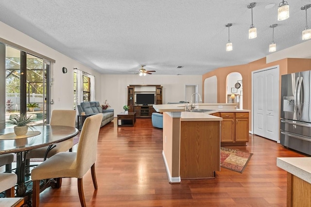 2721 Village Pine Ter, Orlando, FL 32833 - kitchen featuring stainless steel refrigerator with ice dispenser, dark wood-type flooring, light countertops, a textured ceiling, and open floor plan