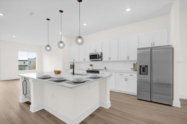 927 City Walk Ln, Oviedo, FL 32765 - kitchen with light countertops, white cabinets, stainless steel appliances, and light wood finished floors