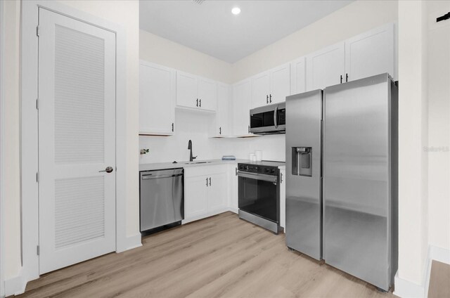 927 City Walk Ln, Oviedo, FL 32765 - kitchen featuring white cabinetry, a sink, appliances with stainless steel finishes, and light wood-type flooring