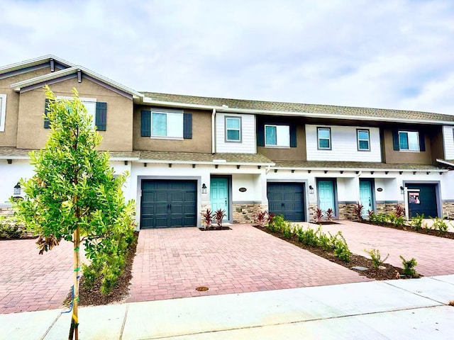 2834 Narcoossee Commons Way, Saint Cloud, FL 34771 - townhome / multi-family property with driveway, a garage, stone siding, and stucco siding