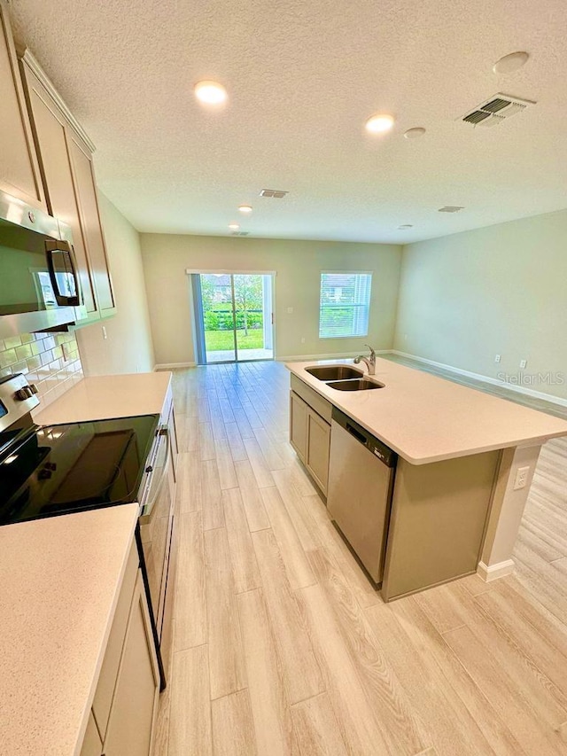 2834 Narcoossee Commons Way, Saint Cloud, FL 34771 - kitchen featuring stainless steel appliances, a sink, light wood-style flooring, light countertops, and a textured ceiling