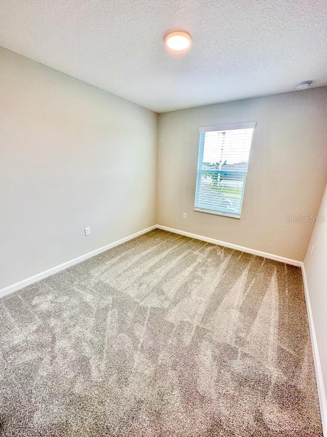 2834 Narcoossee Commons Way, Saint Cloud, FL 34771 - carpeted empty room featuring a textured ceiling, baseboards, and a smoke detector