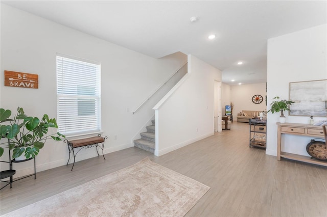 interior space with light wood finished floors, baseboards, recessed lighting, and stairway
