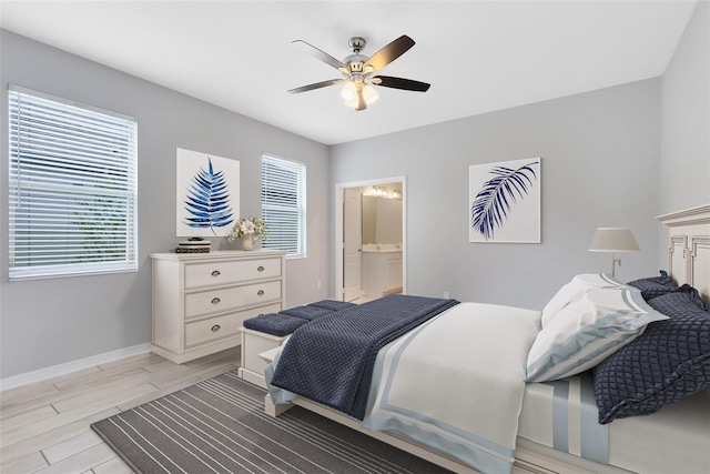 bedroom with wood finish floors, ensuite bath, a ceiling fan, and baseboards