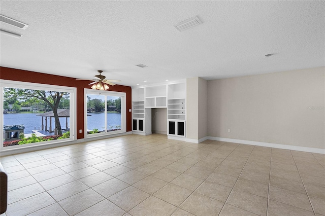 7706 Waunatta Ct, Winter Park, FL 32792 - unfurnished living room featuring a water view, a textured ceiling, baseboards, ceiling fan, and light tile patterned floors