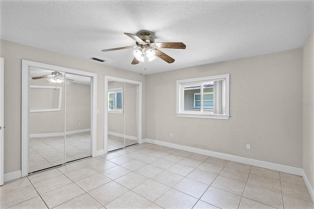 7706 Waunatta Ct, Winter Park, FL 32792 - unfurnished bedroom with light tile patterned flooring, a ceiling fan, multiple closets, baseboards, and visible vents