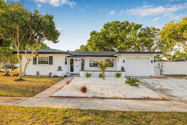 5980 32nd Ave N, Saint Petersburg, FL 33710 - single story home with an attached garage, concrete driveway, a tiled roof, a porch, and stucco siding