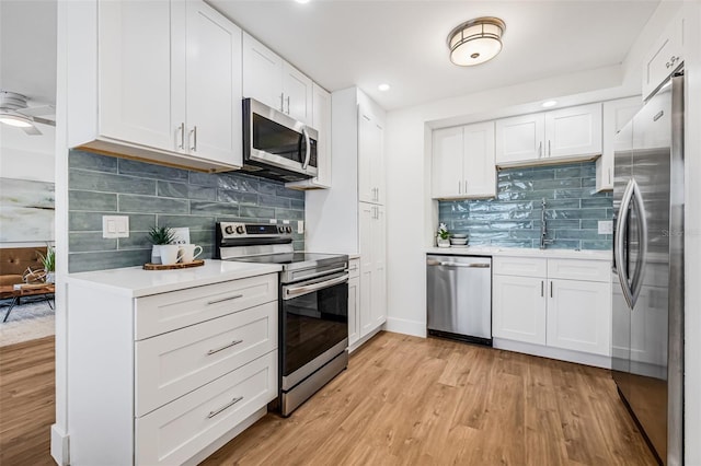 5980 32nd Ave N, Saint Petersburg, FL 33710 - kitchen with appliances with stainless steel finishes, a sink, light wood finished floors, light countertops, and white cabinetry