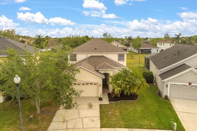 529 Tuten Trl, Orlando, FL 32828 - view of front facade with a front yard, a garage, stucco siding, driveway, and roof with shingles