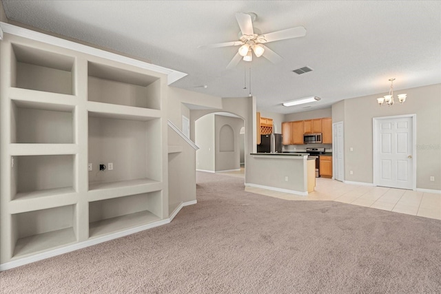 529 Tuten Trl, Orlando, FL 32828 - unfurnished living room with arched walkways, ceiling fan with notable chandelier, light colored carpet, and built in shelves