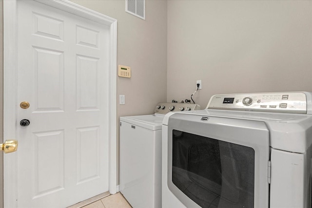529 Tuten Trl, Orlando, FL 32828 - washroom featuring visible vents, washer and clothes dryer, laundry area, and light tile patterned flooring