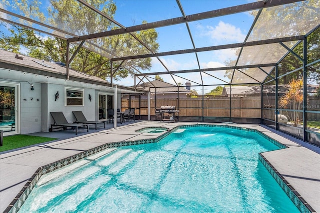 view of pool with a patio, area for grilling, fence, glass enclosure, and a pool with connected hot tub