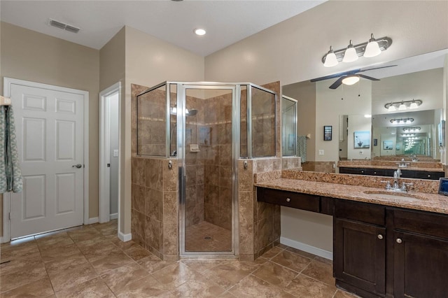 bathroom featuring vanity, baseboards, a shower stall, visible vents, and ceiling fan