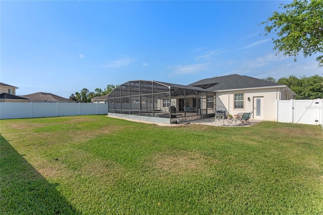 back of property with a patio area, a fenced backyard, a lanai, a gate, and a lawn