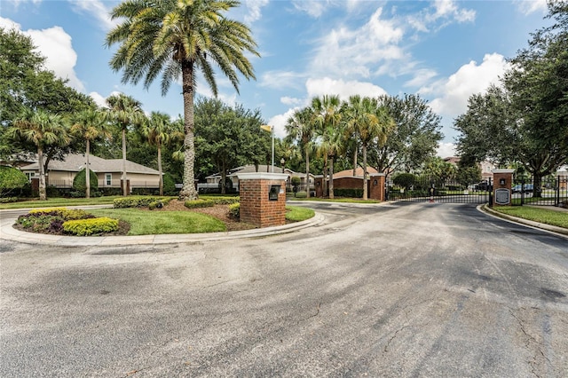 view of road featuring curbs, a gated entry, and a gate