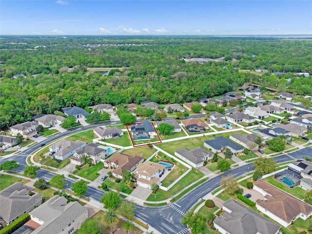 drone / aerial view with a residential view and a view of trees