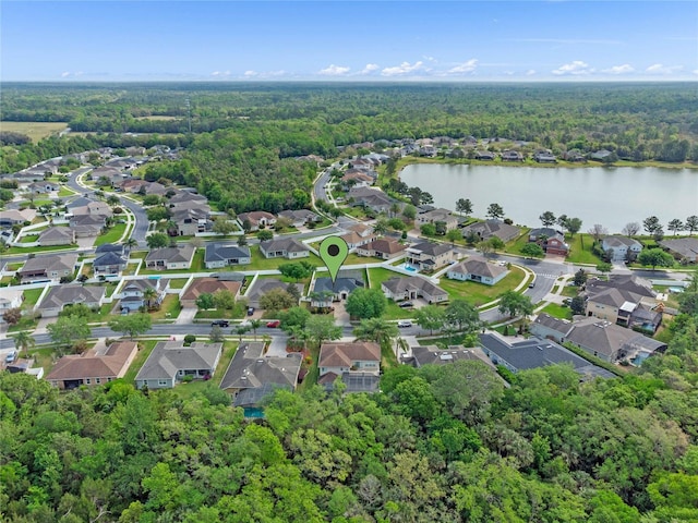 bird's eye view featuring a wooded view and a water view