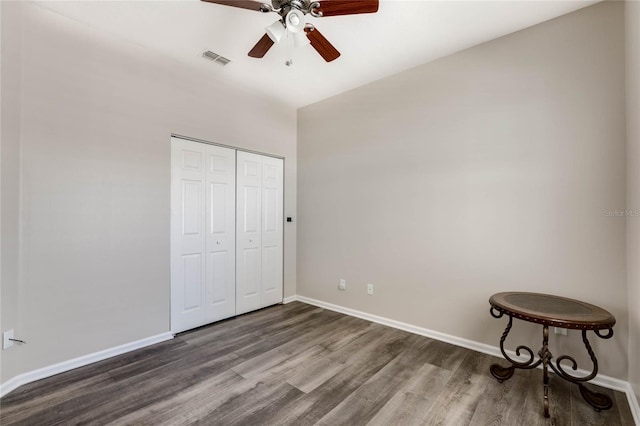 unfurnished bedroom with visible vents, baseboards, a closet, a ceiling fan, and wood finished floors