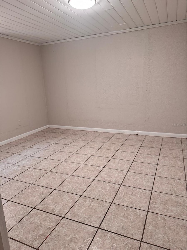 empty room with crown molding, wood ceiling, and a textured wall