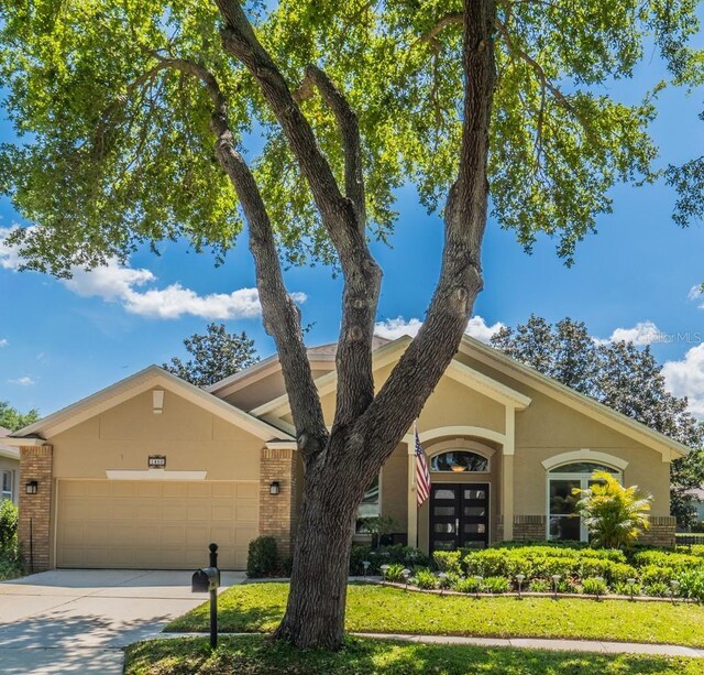 1450 Chessington Cir, Lake Mary, FL 32746 - view of front of home with brick siding, an attached garage, driveway, and french doors