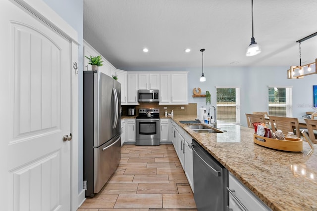 412 5th Ave S, Jacksonville Beach, FL 32250 - kitchen with a sink, white cabinetry, light stone countertops, stainless steel appliances, and decorative backsplash