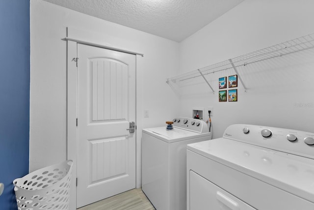 412 5th Ave S, Jacksonville Beach, FL 32250 - washroom featuring a textured ceiling, light wood-style flooring, laundry area, and washer and clothes dryer