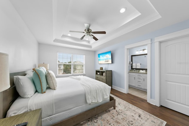 412 5th Ave S, Jacksonville Beach, FL 32250 - bedroom featuring a tray ceiling, dark wood-type flooring, baseboards, ensuite bath, and ceiling fan