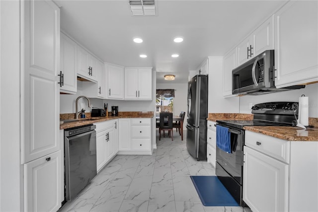 8720 Larwin Ln, Orlando, FL 32817 - kitchen featuring white cabinets, visible vents, marble finish floor, recessed lighting, and black appliances