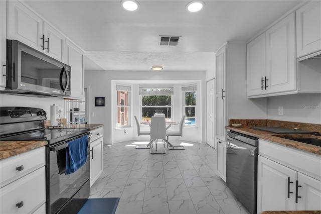 8720 Larwin Ln, Orlando, FL 32817 - kitchen with appliances with stainless steel finishes, marble finish floor, visible vents, white cabinets, and recessed lighting