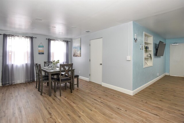 103 Mason Park Dr, Daytona Beach, FL 32117 - dining room with visible vents, baseboards, light wood finished floors, and built in shelves