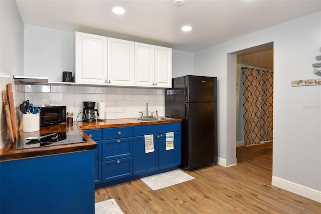 103 Mason Park Dr, Daytona Beach, FL 32117 - kitchen with tasteful backsplash, light wood-style floors, white cabinetry, black appliances, and blue cabinetry