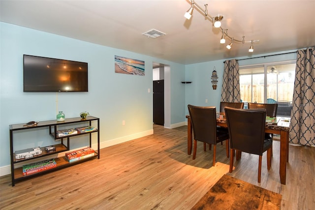 103 Mason Park Dr, Daytona Beach, FL 32117 - dining room with visible vents, baseboards, rail lighting, and wood finished floors
