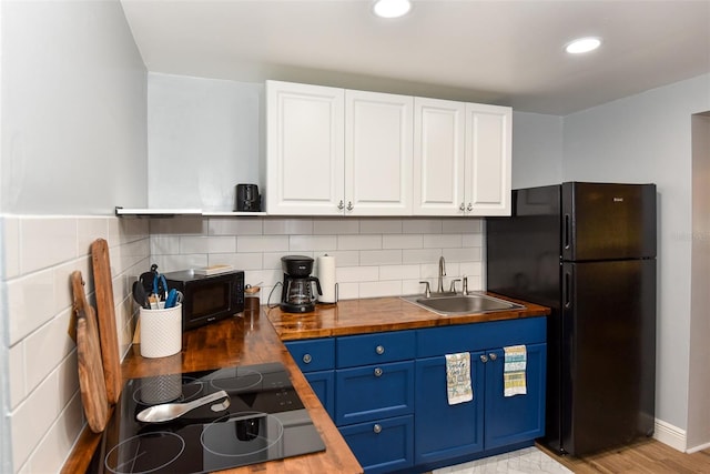 103 Mason Park Dr, Daytona Beach, FL 32117 - kitchen with butcher block counters, blue cabinetry, white cabinets, black appliances, and a sink