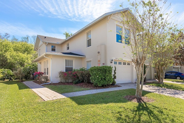 traditional-style home with a front yard, driveway, stucco siding, and an attached garage