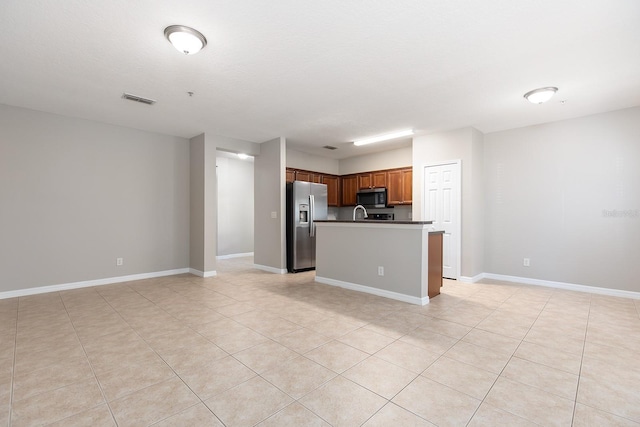 kitchen with open floor plan, dark countertops, stainless steel appliances, baseboards, and visible vents