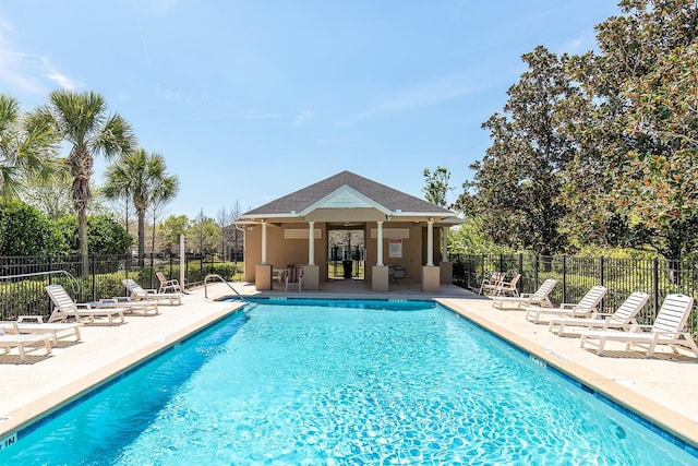 community pool featuring fence and a patio