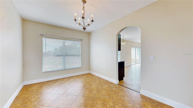 1402 Missouri Pl, Poinciana, FL 34759 - spare room featuring light tile patterned floors, arched walkways, a chandelier, and baseboards