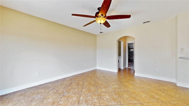 1402 Missouri Pl, Poinciana, FL 34759 - empty room with arched walkways, a ceiling fan, tile patterned flooring, and baseboards