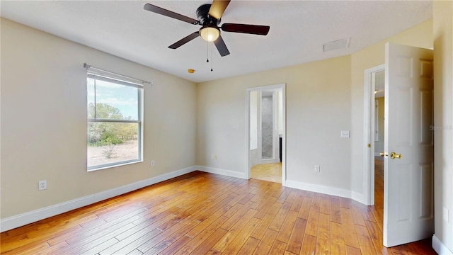 1402 Missouri Pl, Poinciana, FL 34759 - unfurnished room with light wood finished floors, ceiling fan, and baseboards