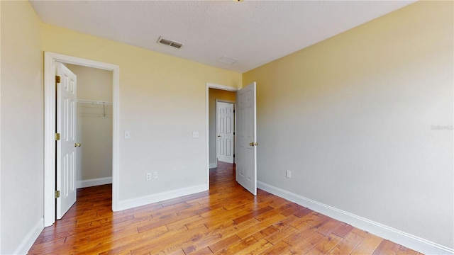 1402 Missouri Pl, Poinciana, FL 34759 - unfurnished bedroom featuring light wood-type flooring, a walk in closet, baseboards, and a closet