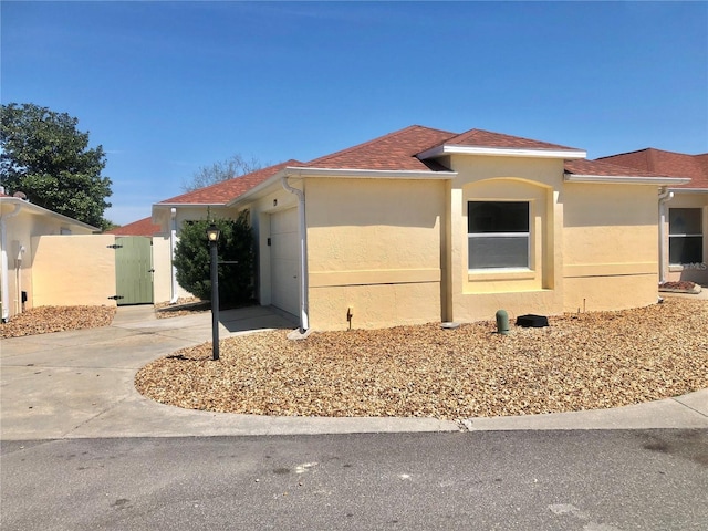 1324 Balboa Ct, The Villages, FL 32159 - view of front of property featuring a gate, stucco siding, a garage, and concrete driveway